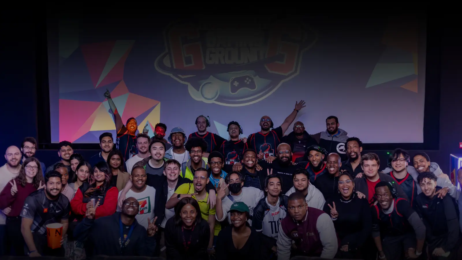 A large group of players and staff gathered under a projection screen at a UGCZA event.
