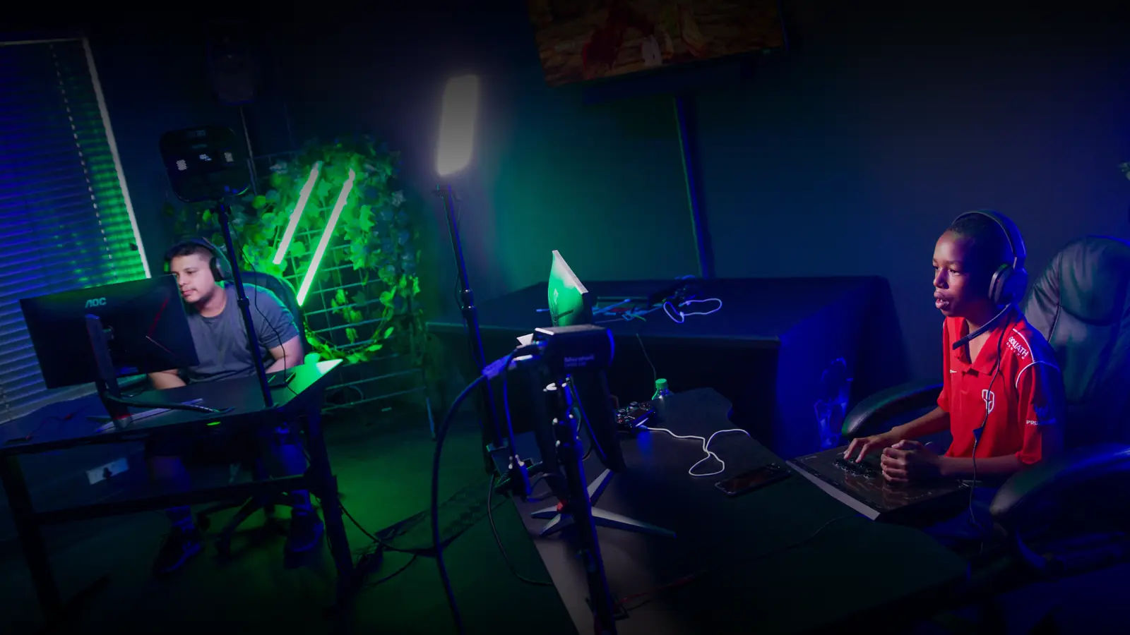 Players at lit stations during a match, seen from behind the setups.
